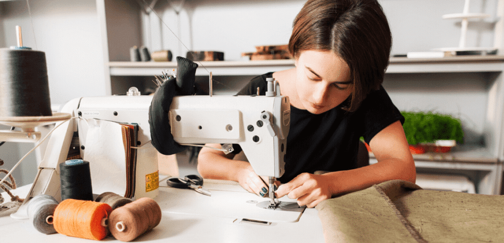 Trabalhadora autonoma costurando em seu atelie de costura
